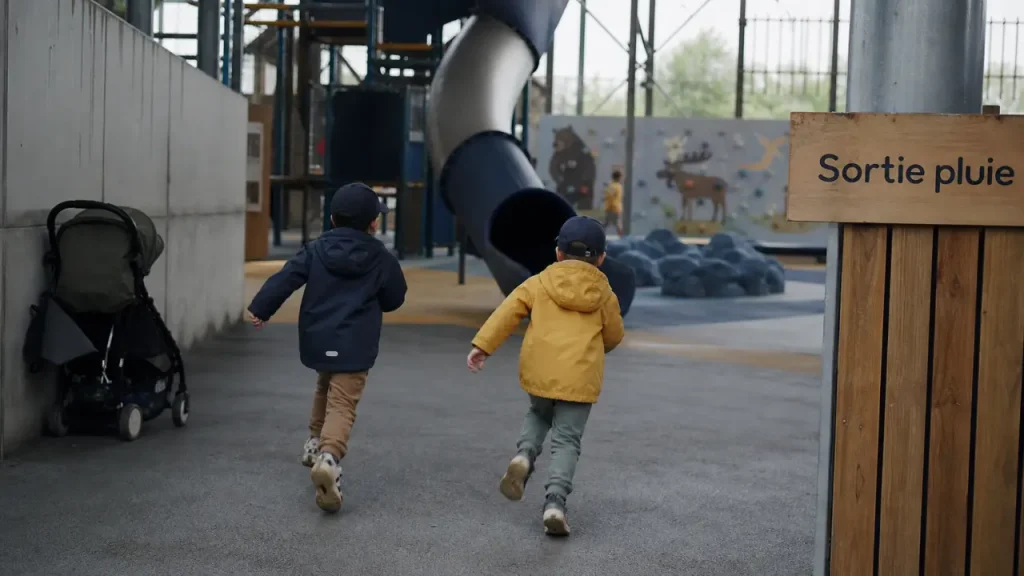 Lille enfant : parc indoor couvert sous la pluie, enfants jouant